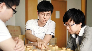 赵鑫鑫（中）在指导队友下棋